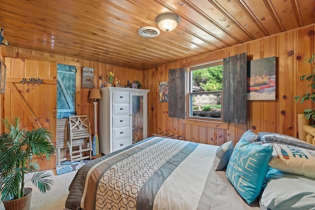 bedroom with visible vents, wood walls, wooden ceiling, and carpet floors