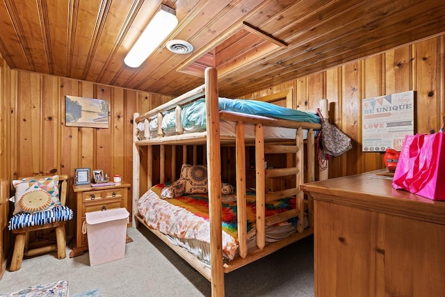 bedroom featuring wooden walls, visible vents, wood ceiling, and carpet