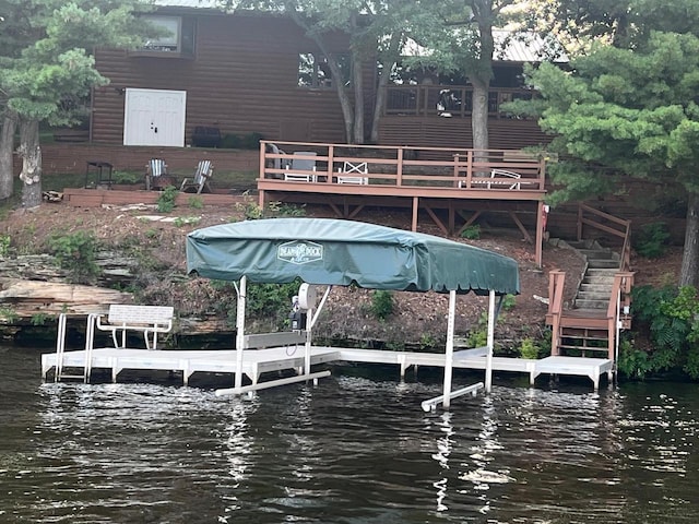 dock area featuring a deck with water view and stairs