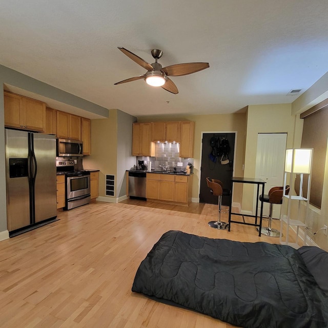 bedroom with visible vents, stainless steel fridge, baseboards, and light wood-style floors