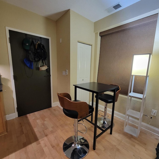 dining space with visible vents, baseboards, and light wood finished floors