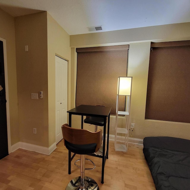 bedroom with light wood-style floors, visible vents, and baseboards