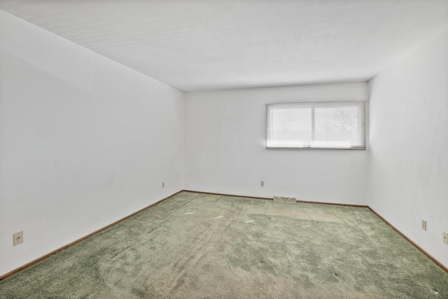 unfurnished room featuring visible vents, baseboards, and carpet