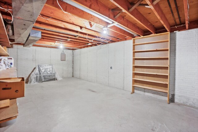 unfinished basement featuring brick wall