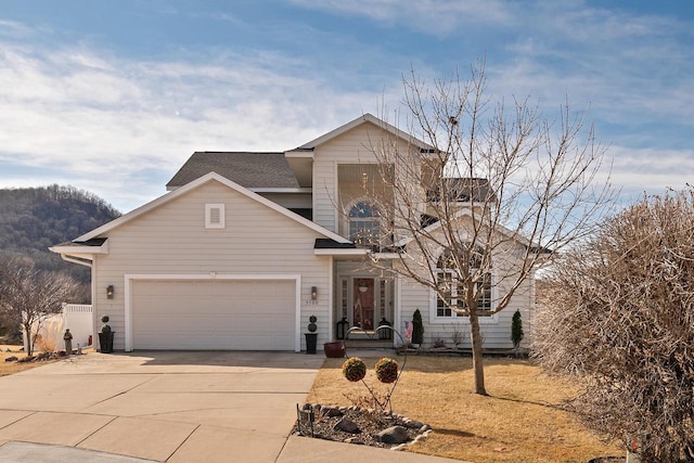 traditional-style house with a garage, driveway, and a shingled roof