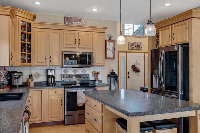 kitchen with light brown cabinetry, stainless steel appliances, and dark countertops