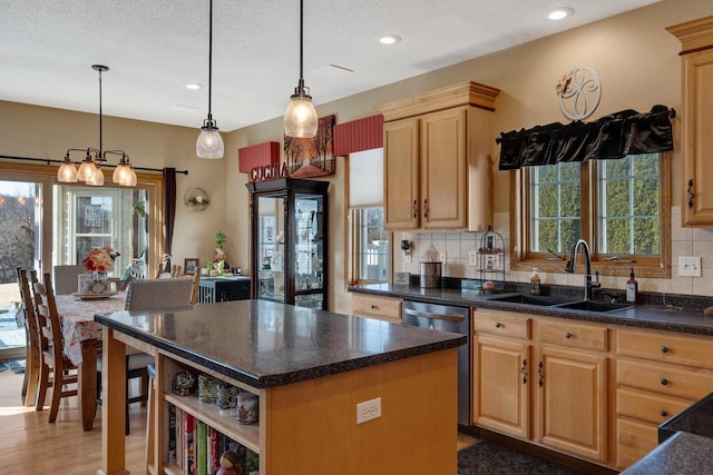 kitchen with tasteful backsplash, a center island, light brown cabinetry, dishwasher, and a sink