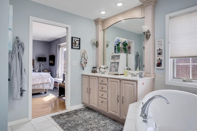 bathroom with tile patterned floors, a wealth of natural light, a bathtub, and ensuite bath