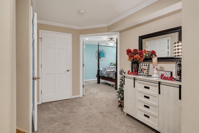 hall with light colored carpet, baseboards, and ornamental molding