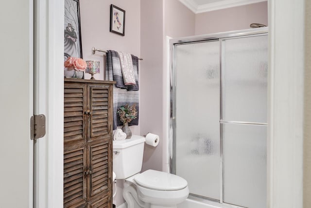 bathroom featuring toilet, a stall shower, and crown molding