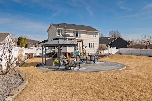 rear view of house with a gazebo, a patio area, a lawn, and a fenced backyard