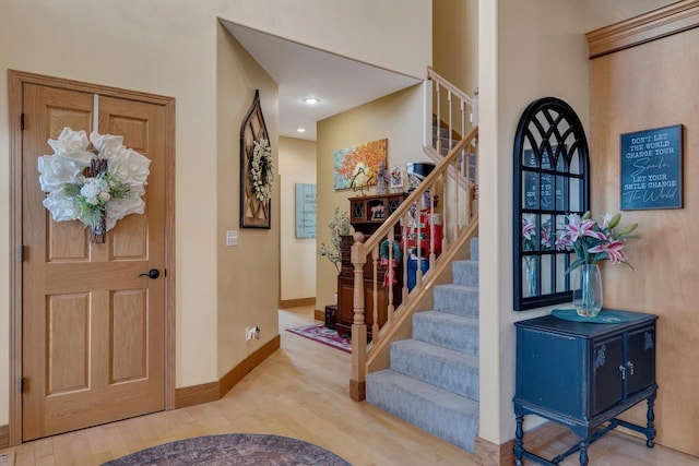 entrance foyer featuring stairway, baseboards, and wood finished floors