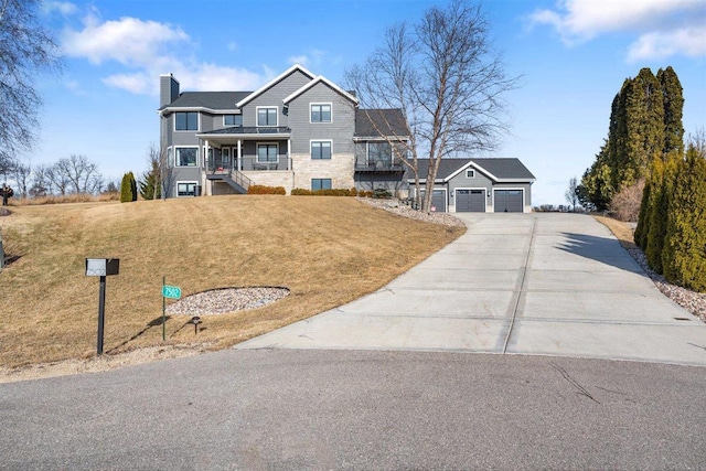 view of front of house featuring a front yard, a porch, a chimney, concrete driveway, and a garage