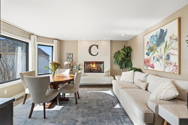 dining space featuring recessed lighting, baseboards, a large fireplace, and wood finished floors