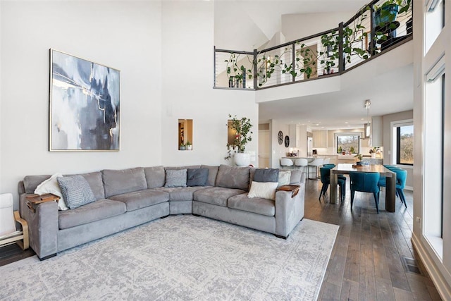 living area featuring visible vents, dark wood-style floors, and a towering ceiling