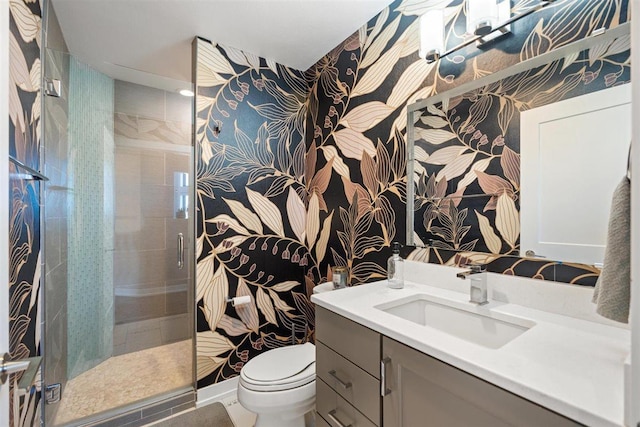 full bathroom featuring wallpapered walls, a shower stall, toilet, and vanity