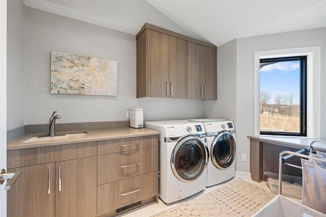 washroom with a sink, cabinet space, and washing machine and dryer