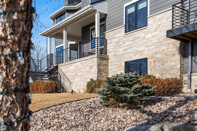 view of property exterior featuring stairway and stone siding