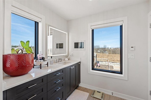 bathroom with vanity, wood finished floors, and baseboards