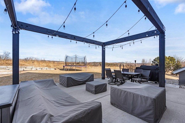 view of patio / terrace with outdoor dining area, a trampoline, and an outdoor living space