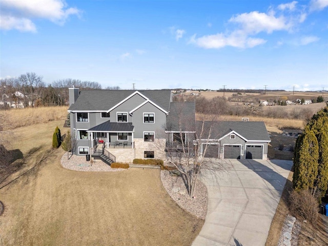 view of front of property featuring a garage, covered porch, concrete driveway, and a chimney