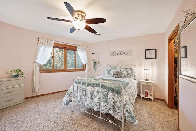 bedroom featuring visible vents, baseboards, light colored carpet, and a ceiling fan