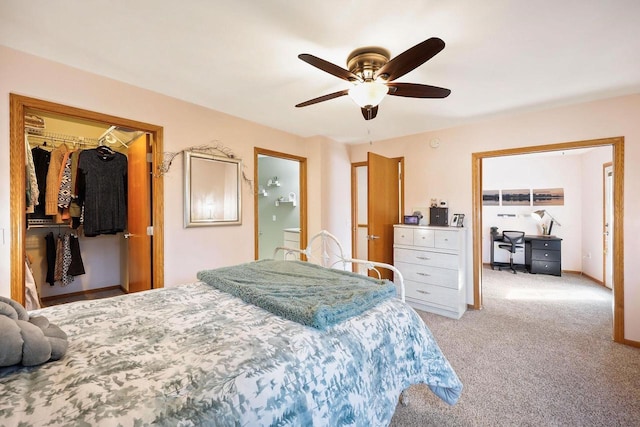 bedroom with baseboards, ceiling fan, a closet, light carpet, and a walk in closet