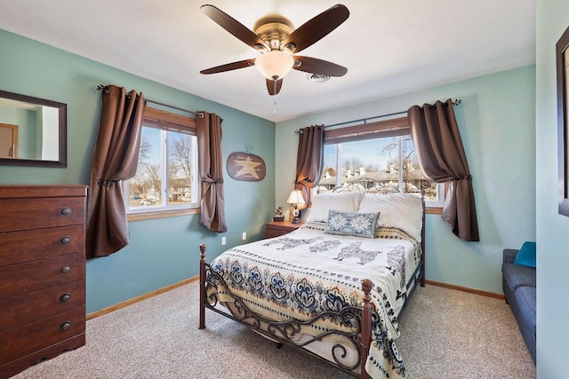 carpeted bedroom with visible vents, baseboards, and a ceiling fan