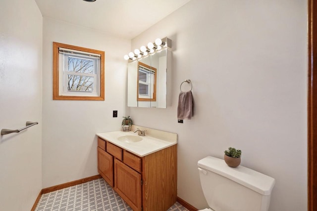 bathroom with toilet, vanity, and baseboards