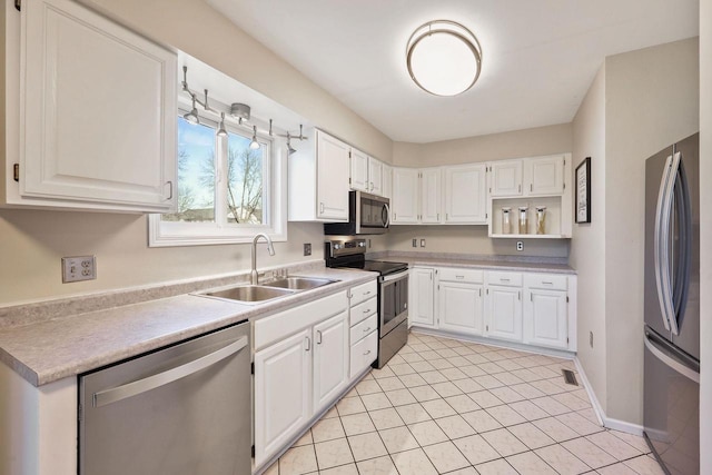 kitchen featuring light countertops, white cabinets, appliances with stainless steel finishes, and a sink