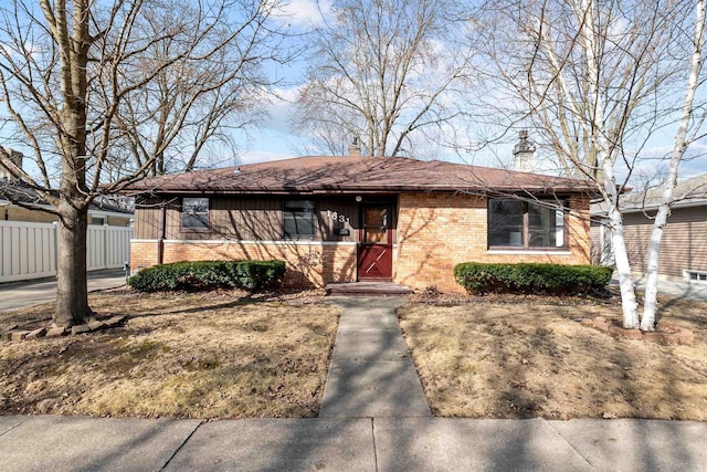 ranch-style house featuring brick siding and fence