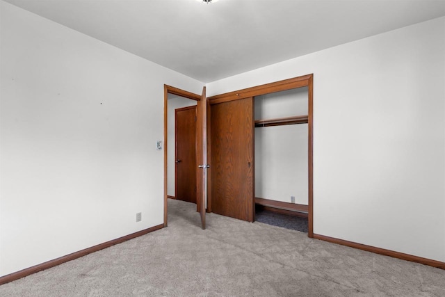 unfurnished bedroom featuring baseboards, a closet, and carpet floors