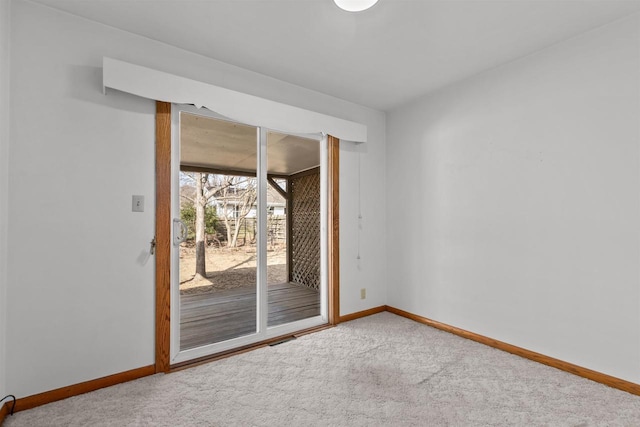 carpeted empty room featuring baseboards