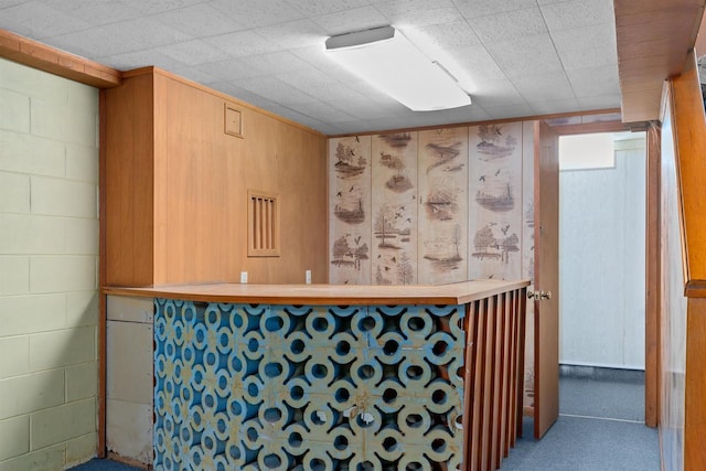 bar featuring concrete block wall and carpet floors