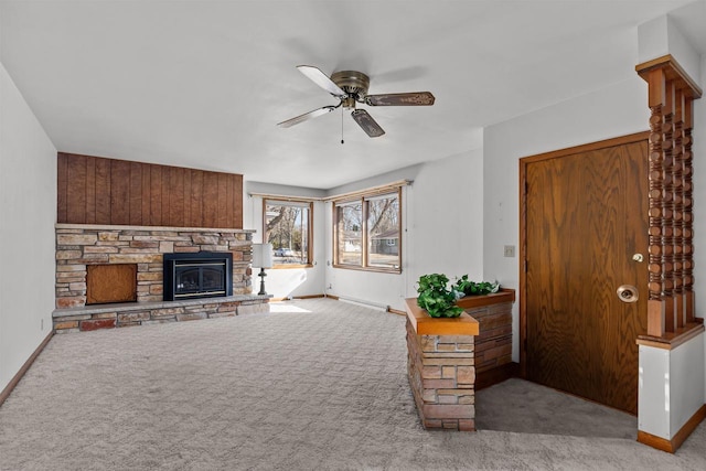 carpeted living area featuring baseboards, a ceiling fan, and a fireplace