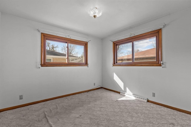 empty room with carpet flooring, baseboards, and plenty of natural light