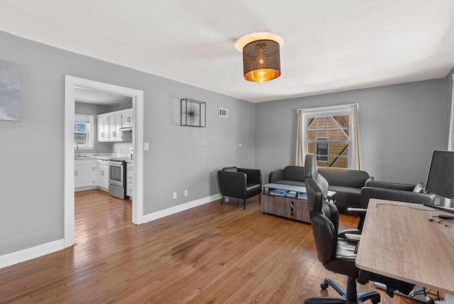 home office featuring visible vents, baseboards, and light wood-style floors