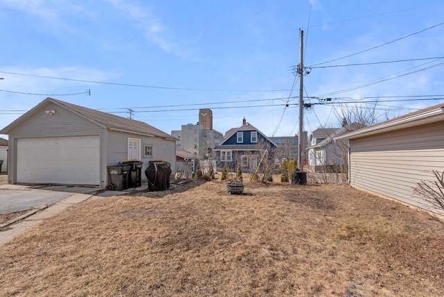 view of yard featuring a garage, a fire pit, and an outdoor structure