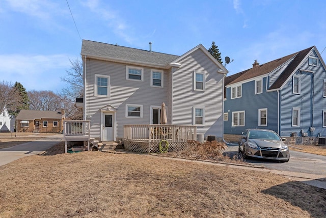 rear view of property featuring a deck, central AC, and driveway