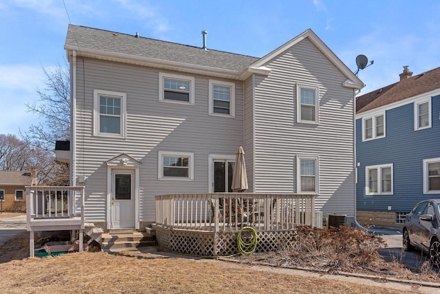 rear view of property featuring a deck and roof with shingles