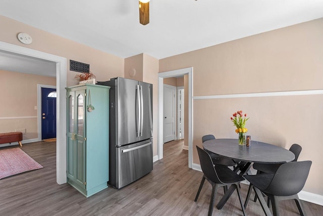 dining room featuring a ceiling fan, baseboards, and wood finished floors