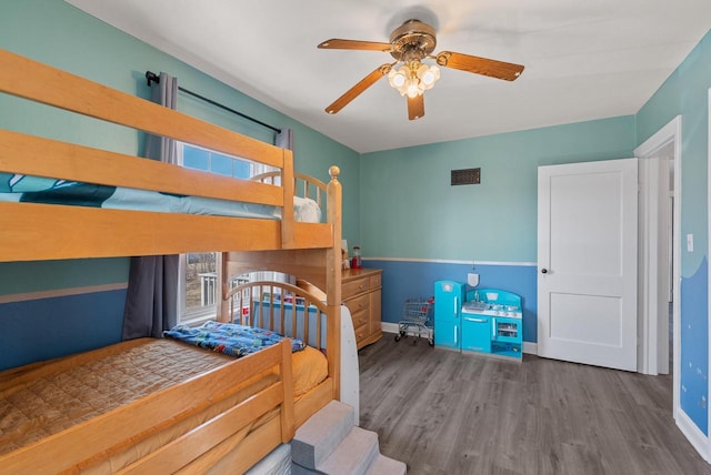 bedroom with wood finished floors, baseboards, and ceiling fan