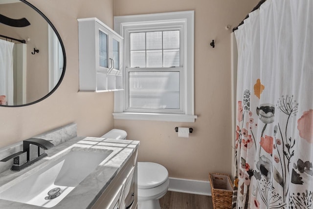 full bath with vanity, a shower with curtain, wood finished floors, baseboards, and toilet