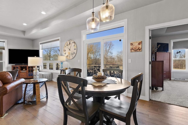 dining area featuring hardwood / wood-style floors, baseboards, visible vents, recessed lighting, and a raised ceiling