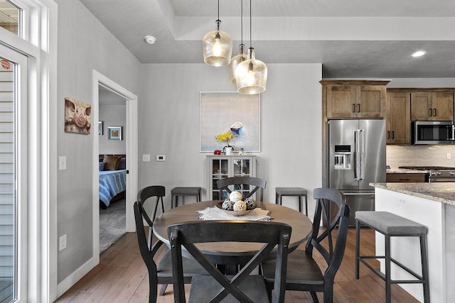 dining area with recessed lighting, light wood-style floors, and baseboards