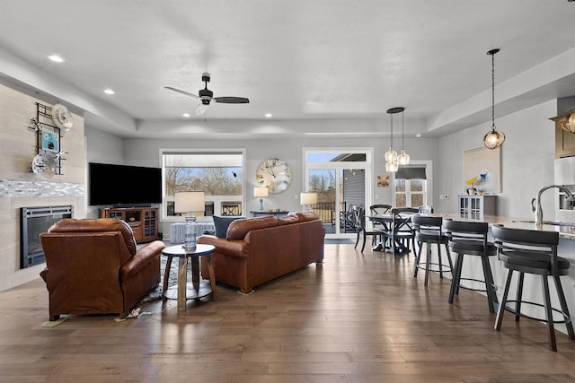 living room featuring ceiling fan, recessed lighting, a fireplace, hardwood / wood-style flooring, and heating unit