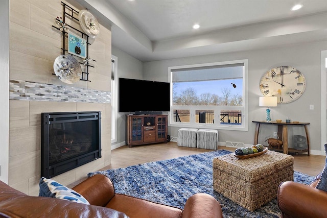 living area with wood finished floors, visible vents, baseboards, a fireplace, and recessed lighting