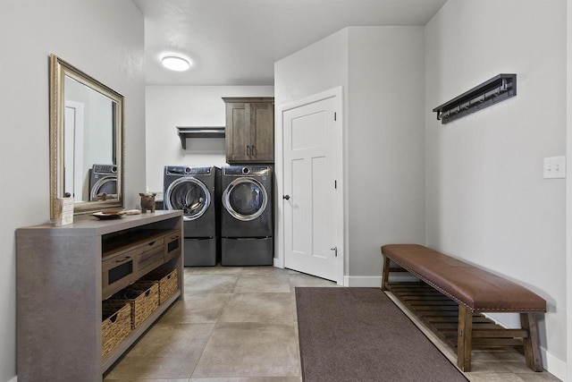 laundry area with washing machine and clothes dryer, cabinet space, and baseboards