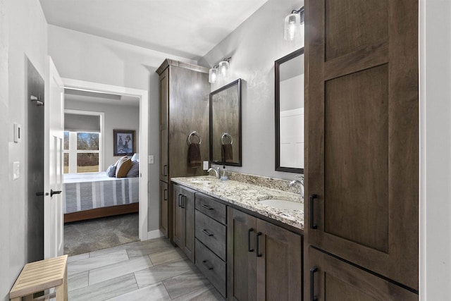 full bath featuring ensuite bath, double vanity, and a sink