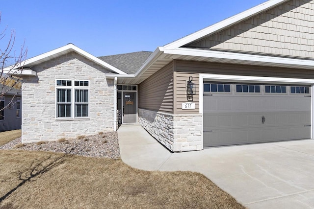 view of front facade featuring stone siding, concrete driveway, a garage, and roof with shingles